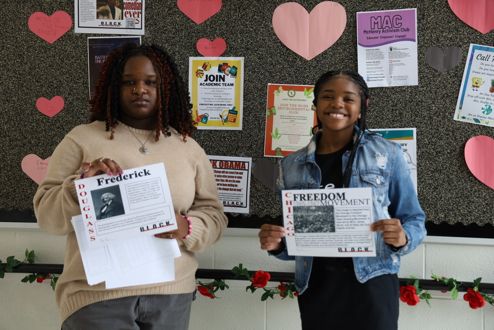 BLACK club members installing posters about well-known Black Americans for Black History Month