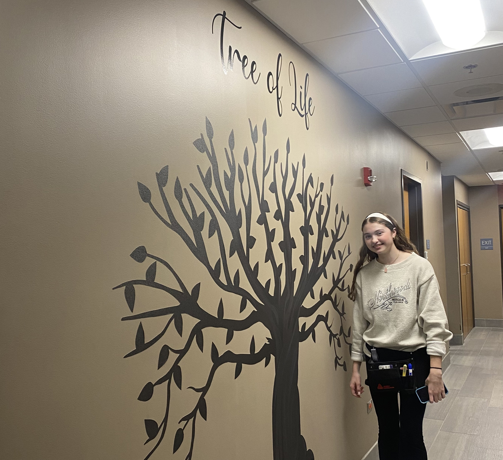 MCHS student Mollie Hobson stands in front of Tree of Life she designed and produced