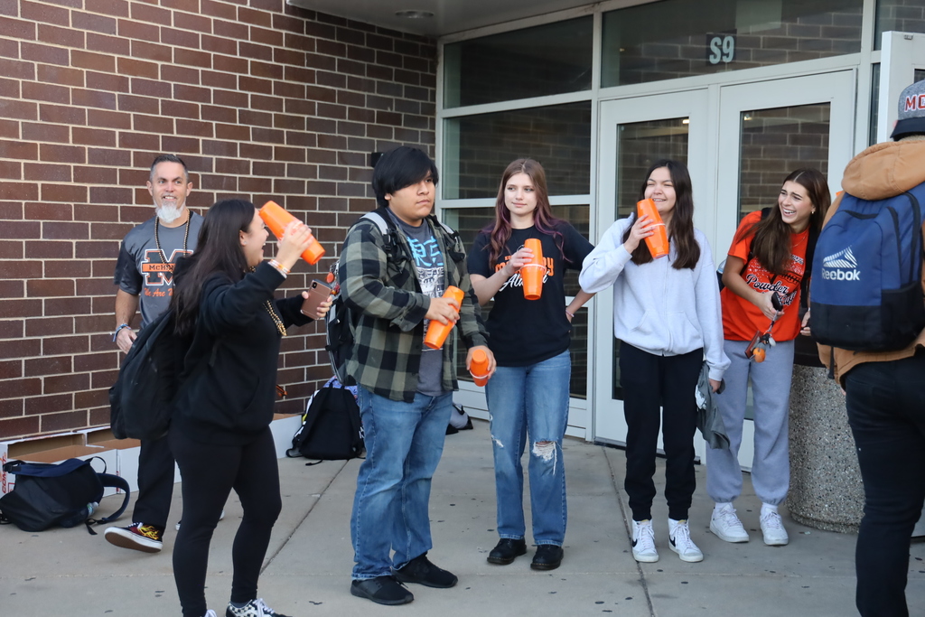 Students  greeting other students with noise makers at the school