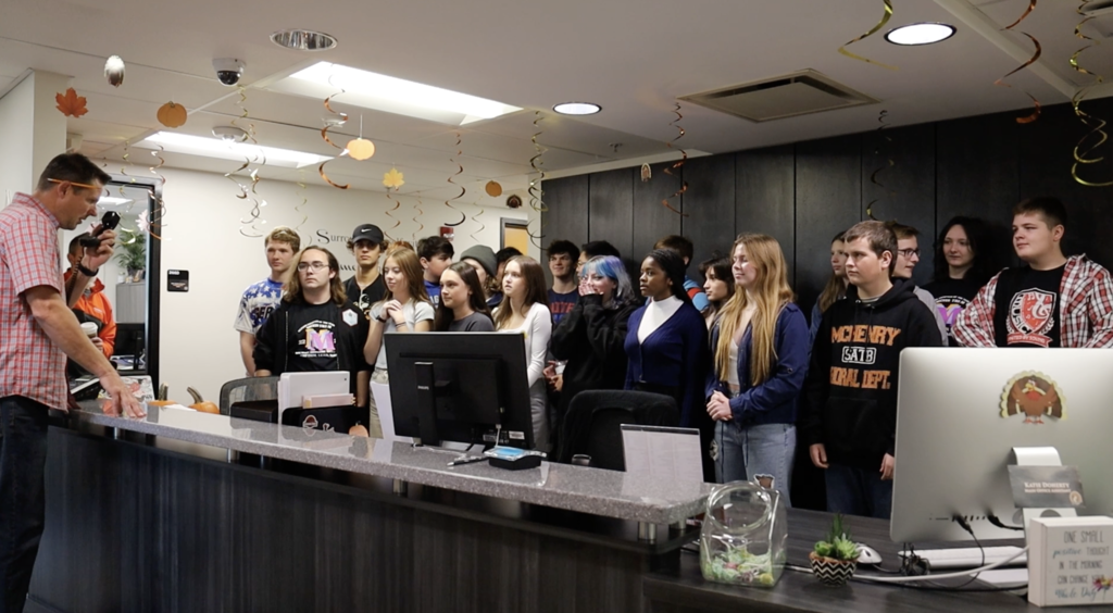 Choir teacher and students singing on the intercom