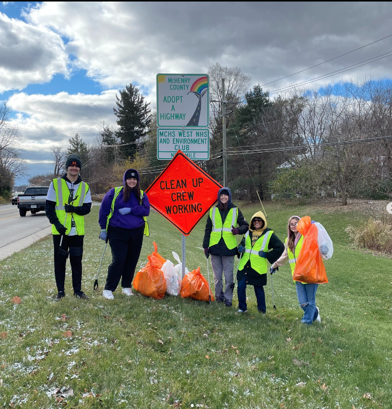 Environment club with a clean up crew working sign on the side of the road