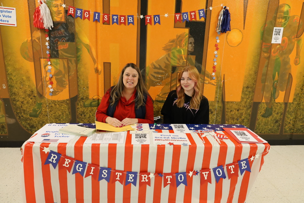 Mrs. Rockweiler and activism student at a patriotic "Register to Vote" booth