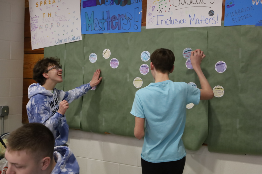Students hanging inclusion stickers
