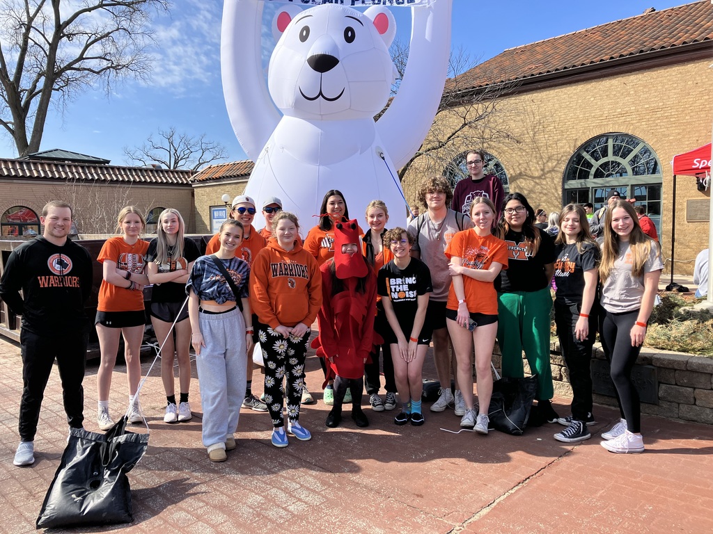 Students posing by the Polar Plunge blowup polar bear. One student in lobster costume