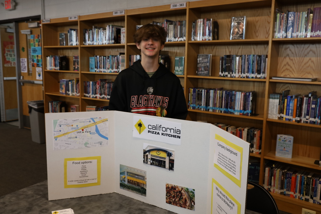 A student in front of a California Pizza Kitchen poster