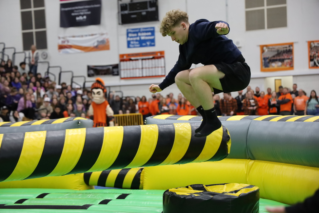 A student jumping over an inflatable tube