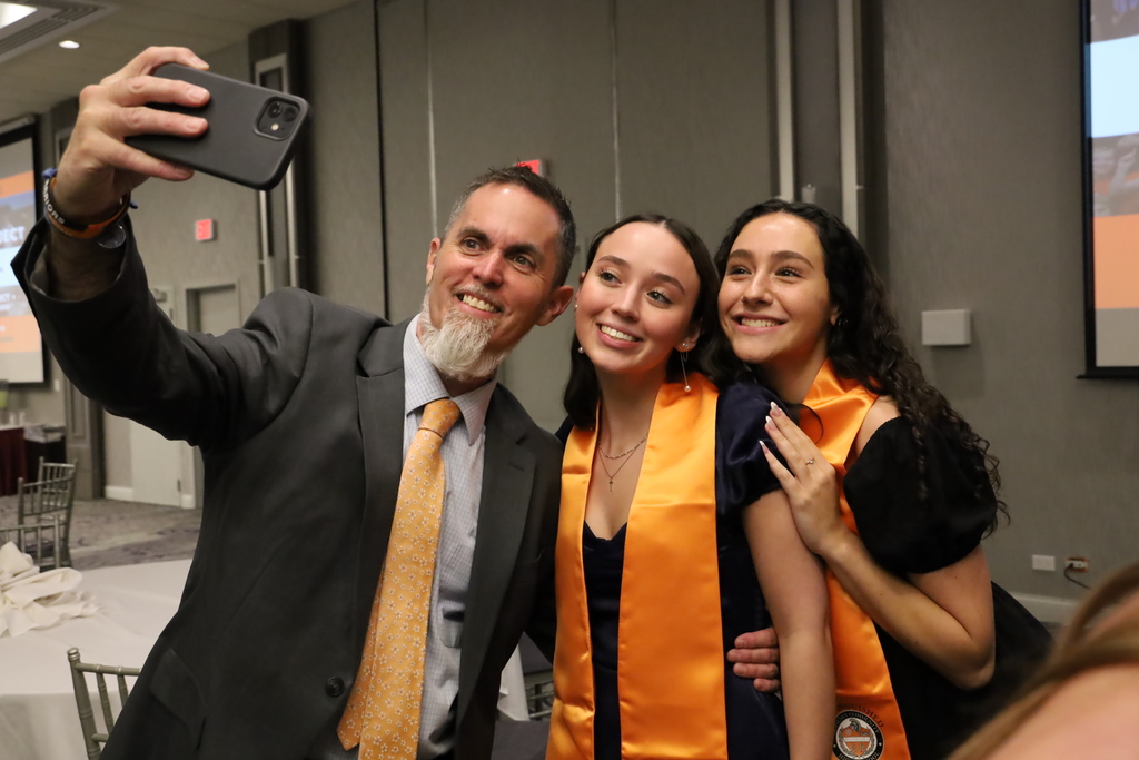 Principal taking selfie with two students