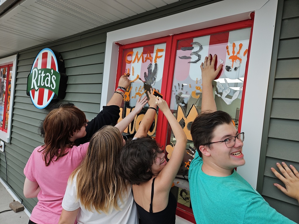 A group of students putting their hand prints on the window