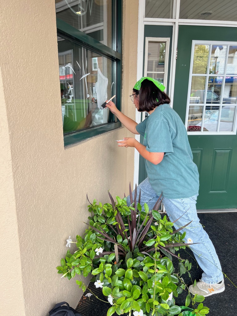 Student painting a window