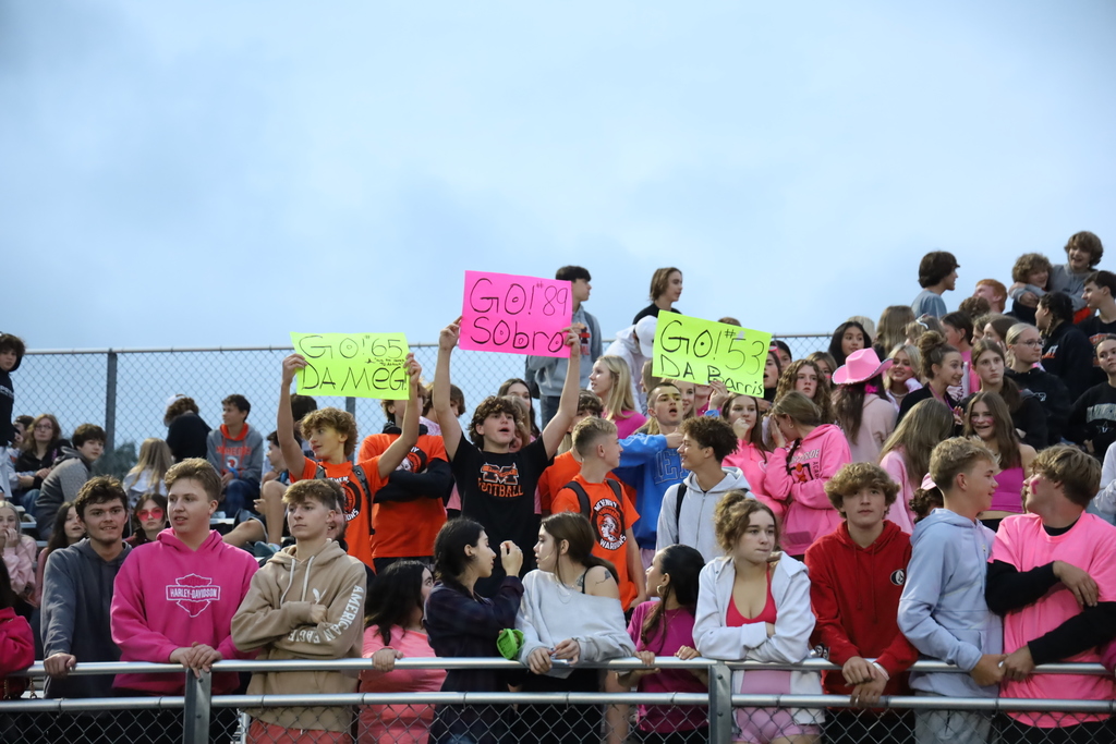 Students holding signs to cheer on powder puff